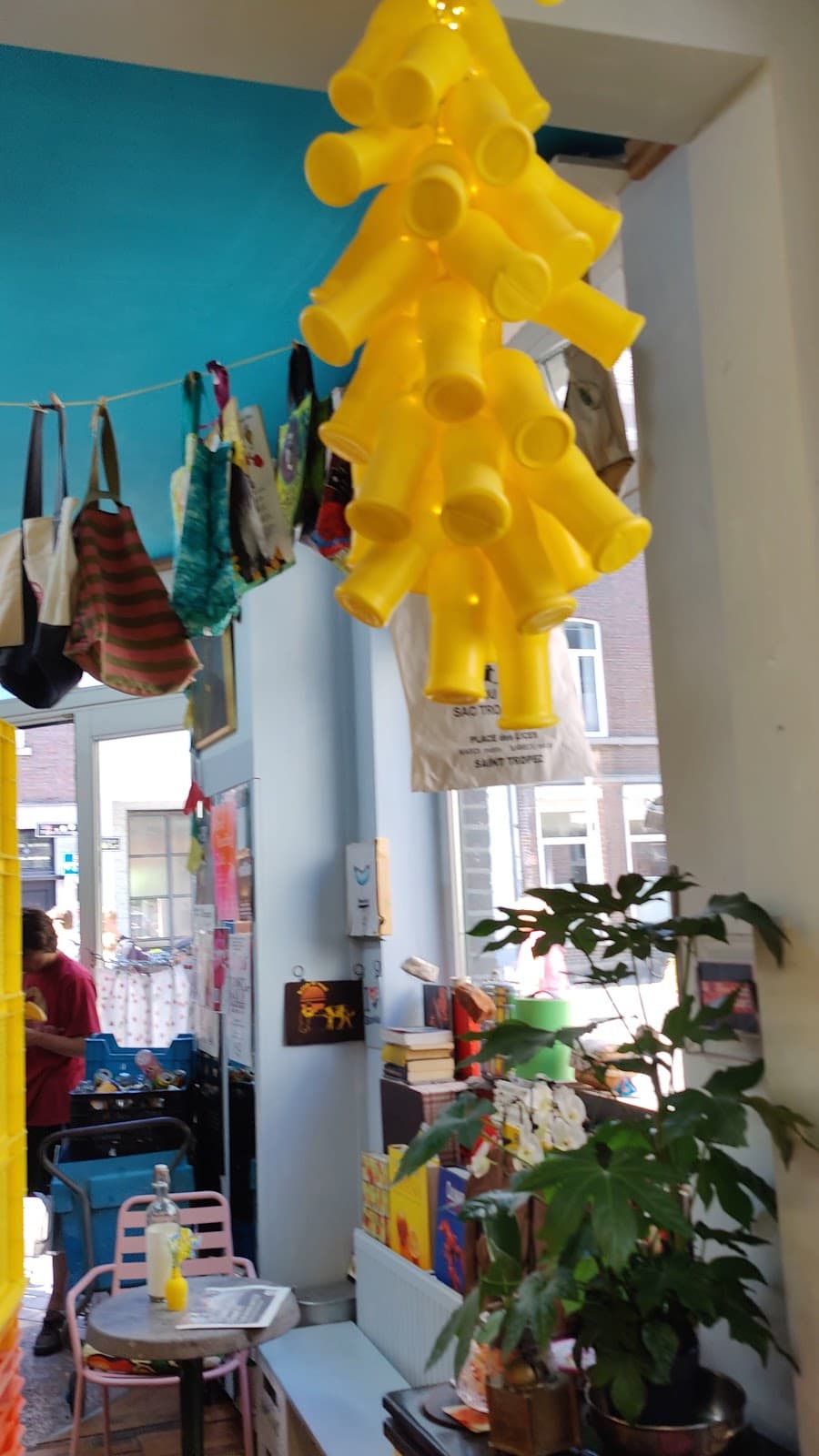 Het kunstige interieur van Cato by Cato met gele plastic bekers en kleurrijke tassen